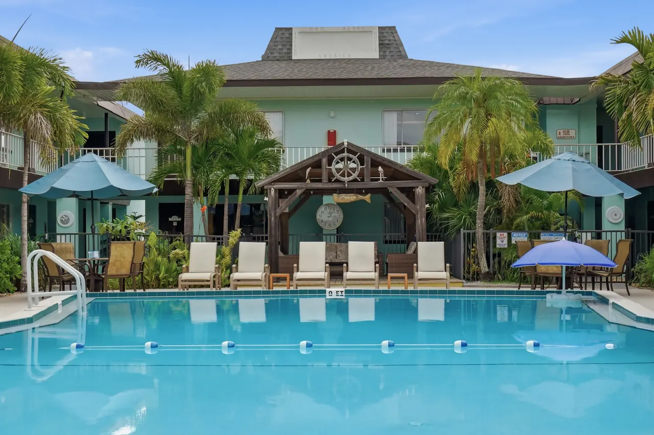 Sunny pool and palms beside the hotel building